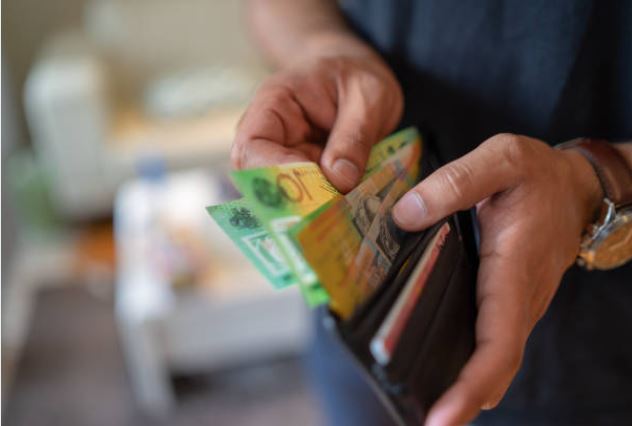 person taking out cash from a wallet